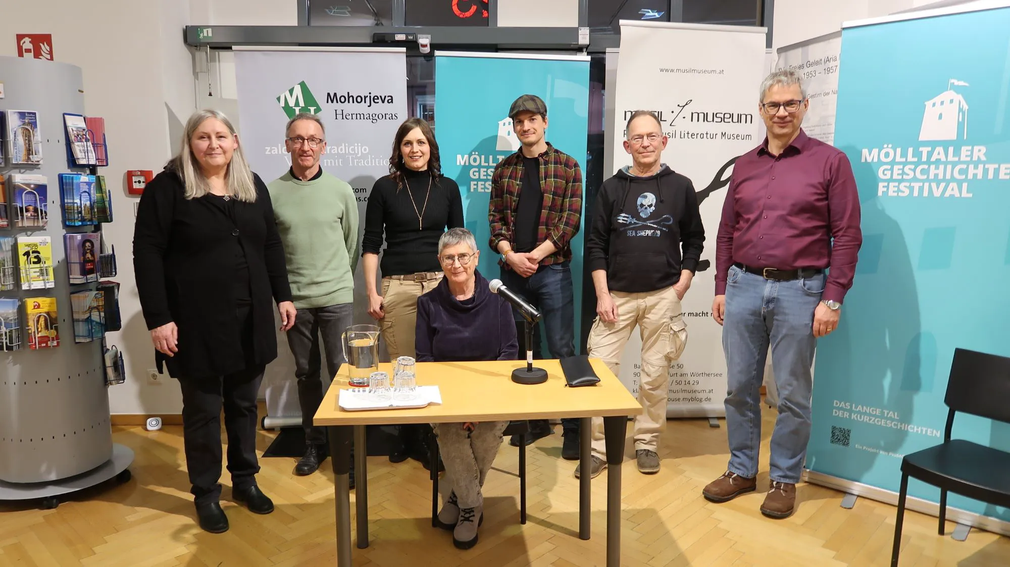 MF Melitta Fitzer (links) und Verlagsleiter Hanzi Filipič (rechts) im Kreis der Autoren des Mölltaler Geschichten-Sammelbandes